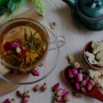 rose tea in a glass cup with dried roses on the table