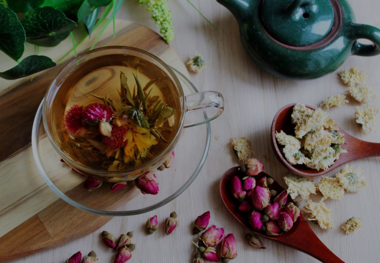 rose tea in a glass cup with dried roses on the table